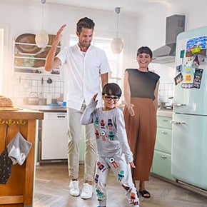 Family of 2 adults and a child having fun in the kitchen