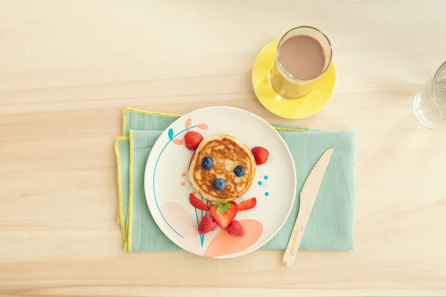 Pancakes decorated with berries and served with a glass of Nesquik Pancakes decorated with berries and served with a glass of Nesquik